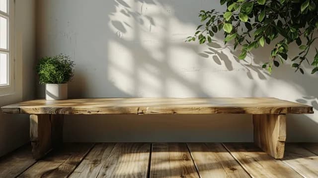 Sunlit wooden counter table stands against a wall with leafy shadows across the floor.